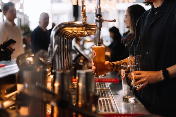 A man pours drinks at a pub.